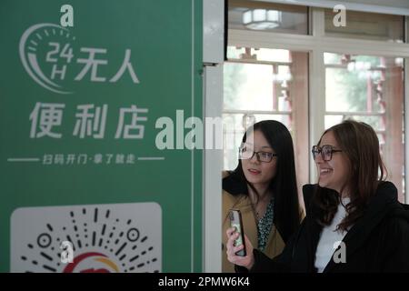 (230415) -- BEIJING, April 15, 2023 (Xinhua) -- Maria (R) scans a QR code on a vending machine at the Yenching Academy of Peking University in Beijing, capital of China, April 13, 2023. Maria Eduarda Variani, Rafaela Viana dos Santos, Manuela Boiteux Pestana, and Marco Andre Rocha Germano are Brazilian students studying in the Master of China Studies program at the Yenching Academy of Peking University in China. The four of them have been interested in Chinese culture since they were young. After arriving in Beijing, they have been impressed by the Chinese capital's profound cultural herit Stock Photo