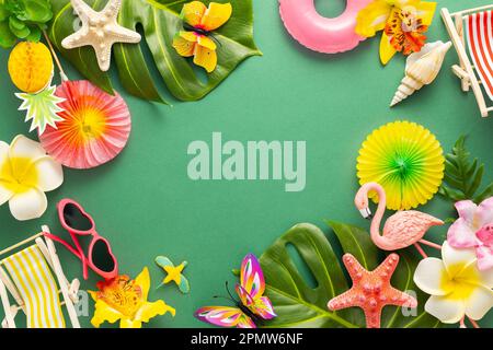 Exotic tropical summer background. Summer beach party concept. Pink flamingo, tropical leaves, orchid flowers and other accessories on green backgroun Stock Photo