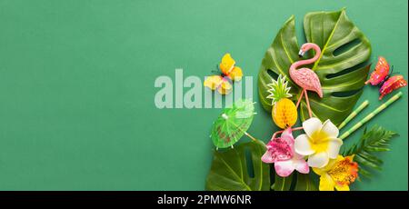 Exotic tropical summer background. Summer beach party concept. Pink flamingo, tropical leaves, orchid flowers and other accessories on green backgroun Stock Photo