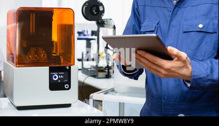 Engineer using digital tablet to program 3d printer. High quality photo Stock Photo
