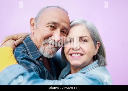 Portrait of happy senior couple hugging and looking at camera outdoor - Elderly joyful lifestyle Stock Photo