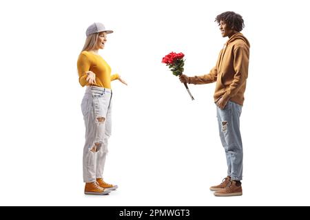 Full length profile shot of a gen z african american man giving a bunch of roses to a caucasian girl isolated on white background Stock Photo