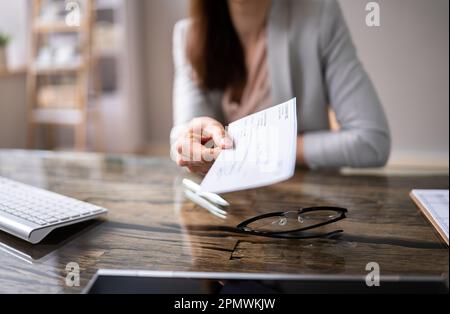 Close-up Of A Businessperson's Hand Holding Cheque In Office Stock Photo