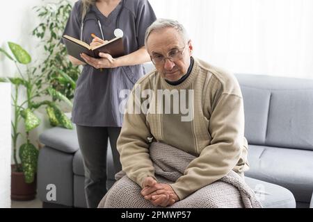 Kind female doctor embracing encouraging senior male patient in hospital. Happy healthy older man and his physician enjoying talking at nursing home Stock Photo