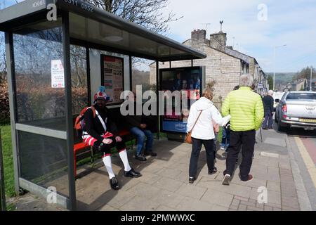 Member of Britannia Coconutters sat waiting at a bus stop during their annual perambulation of the town of Bacup in Lancashire on Easter Saturday Stock Photo