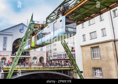 Historic suspended monorail leaving the central station in Wuppertal, Germany Stock Photo