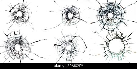 bullet holes and numerous cracks on a plain white glass background, evoking a sense of danger and destruction. The bullet holes are the central focus Stock Photo