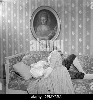 As if in the 18th century. Actors Jarl Kulle and Maj-Britt Nilsson in a scene taken inside the royal castle Drottningholm in Stockholm. The photograph was originally published to illustrate a historic novel running in several episodes in a magazine 1956. The room, furniture and clothing are typical of the 18th century Sweden. Conard ref EC3168 Stock Photo