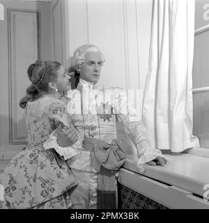 As if in the 18th century. Actors Jarl Kulle and Maj-Britt Nilsson in a scene taken inside the royal castle Drottningholm in Stockholm. The photograph was originally published to illustrate a historic novel running in several episodes in a magazine 1956. The room, furniture and clothing are typical of the 18th century Sweden. Conard ref EC3168 Stock Photo