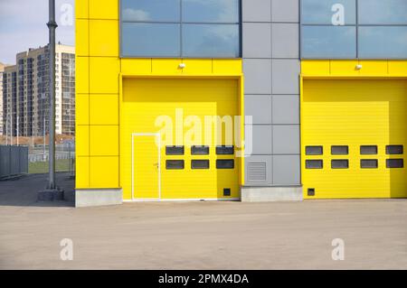 Modern new garage doors. Bright yellow sectional doors. Stock Photo