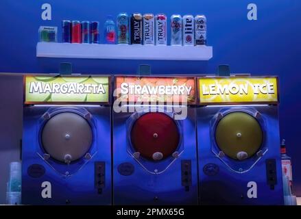 Slushy machine with refreshments and various canned and bottled beverages for sale on a shelf at the High Roller in Las Vegas, Nevada USA. Stock Photo