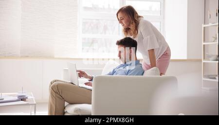 Family Couple Using Laptop On Couch Online Stock Photo