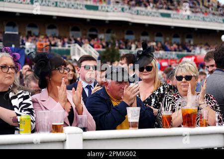 Racegoers take part in a minutes applause on the anniversary of the Hillsborough disaster on day three of the Randox Grand National Festival at Aintree Racecourse, Liverpool. Picture date: Saturday April 15, 2023. Stock Photo