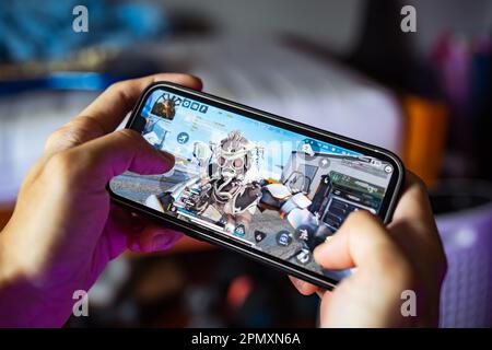 Bangkok, Thailand - April 15, 2023: Gamer playing Apex Legends Mobile game on iPhone 13. Stock Photo