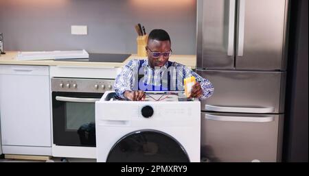 Washing Machine Appliance Repair And Install In Kitchen Stock Photo