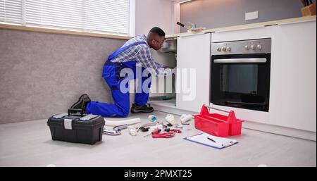 Plumber Cleaning Kitchen Drain And Pipe Using Tools Stock Photo