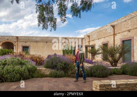 A Man visiting the old rustic model school with cactus in Mineral de Pozos Guanajuato Mexico Stock Photo