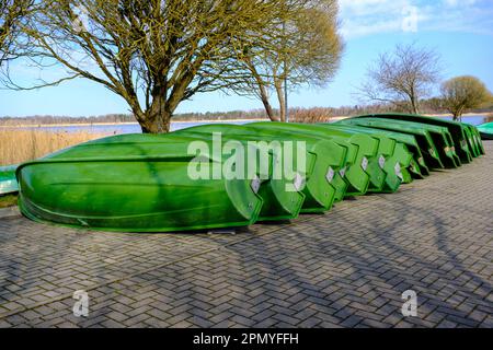a lot of plastic boats in green color on the shore. Stock Photo