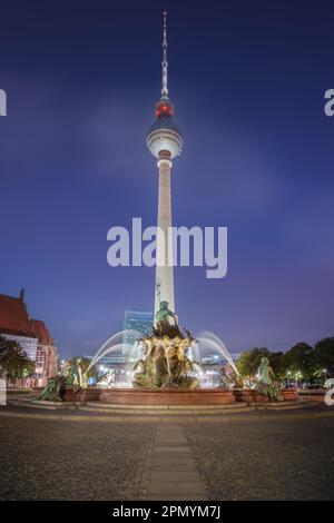 TV Tower (Fernsehturm) at night and Neptune Fountain - Berlin, Germany Stock Photo