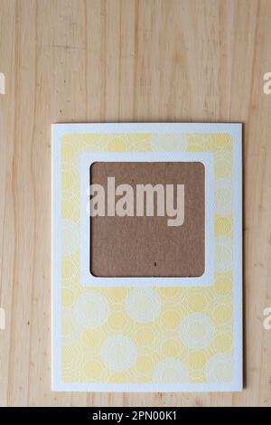 DIY paper card with window and decorative yellow pattern on wood Stock Photo