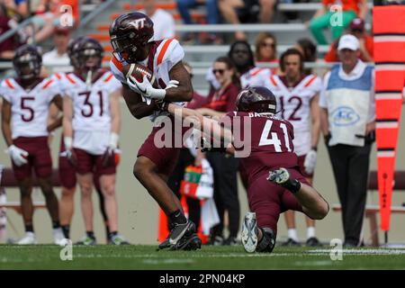 Virginia Tech running back George Bell (34) tries to stretch the ball  across the goal line as Virginia linebacker Clint Sintim (51) grabs the  ball during the Virginia-Virginia Tech college football game