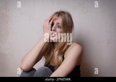 sad young woman with tear-stained face and smudgy makeup from crying Stock Photo