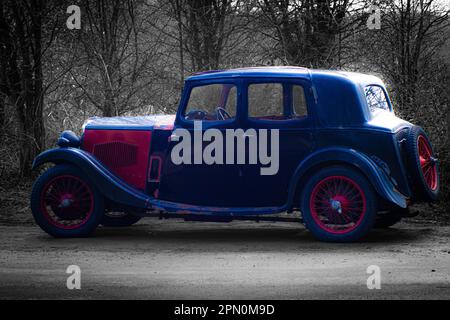 Old blue and red vehicle on a wavy black and white background Stock Photo