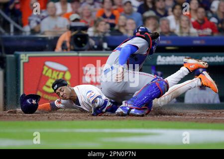 Houston Astros' Jeremy Pena, right, slides to score as Texas Rangers  catcher Jonah Heim, left, waits for the throw on a sacrifice fly by Yanier  Diaz during the fourth inning of a