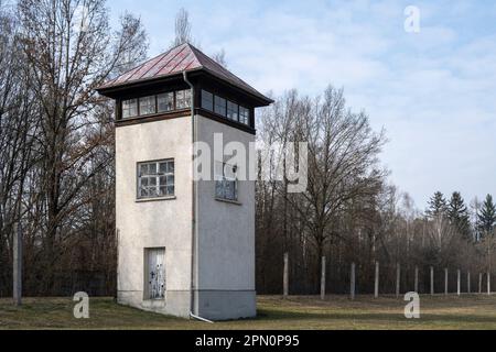 view of a guard tower at Dachau concentration camp from inside the camp with perimeter fence in the background Stock Photo