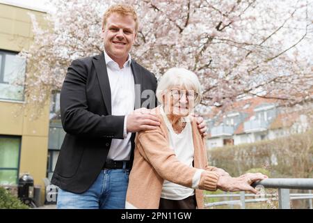 Kirchheim Unter Teck, Germany. 31st Mar, 2023. Charlotte Kretschmann stands with her grandson Peter Bauer in front of the retirement home. At 113, she is the oldest woman in Baden-Württemberg. She not only spends everyday life with her grandchildren and distant relatives, but also shares it with the world via social media. With her almost 5,000 followers, the 113-year-old shares snapshots from her life every now and then, whether it's from shopping, Christmas or an excursion. Credit: Julian Rettig/dpa/Alamy Live News Stock Photo