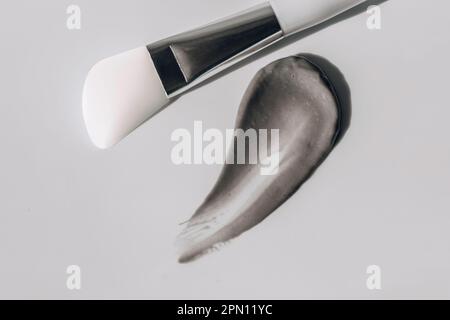 facial mask smeared with makeup brush on white background Stock Photo