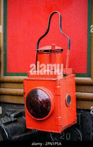 Old red railroad lamp on a steam engine Stock Photo