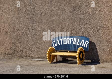 A metal bench made locally from Gear wheels of a tracked Farm Bulldozer on the property of the local haulage company of Geddes. Stock Photo