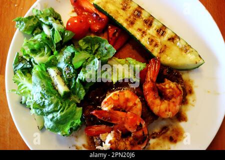Beef and Reef meal with eye fillet and tiger prawns, zucchini, tomatoes, cucumber and salad Stock Photo