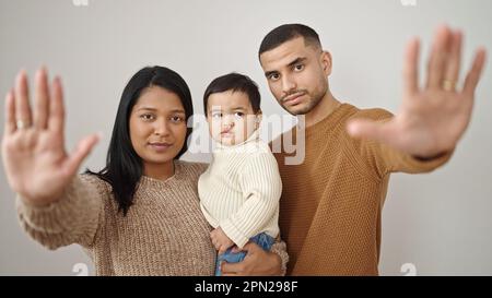 Couple and son hugging each other doing stop gesture over isolated white background Stock Photo