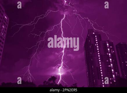 Pop Art Surreal Style of Amazing Lightning Strikes in Dark Purple Colored Urban Night Sky Stock Photo