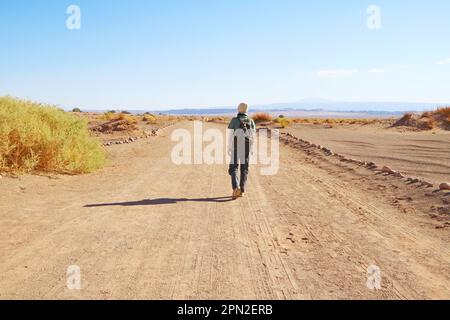 Traveler Walking on the Desert Road of Aldea de Tulor Archaeological Site in Atacama Desert, Northern Chile, South America Stock Photo