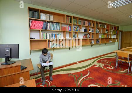 Library of the medrese. Muslim boy reading a book. October 21, 2018. Islamic culture centre, Kiev, Ukraine Stock Photo