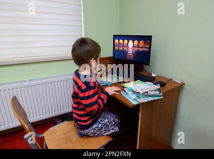 Computer room of the medrese. Little boy sitting in front a monitor of a computer. Islamic culture centre. October 21, 2018. Kiev, Ukraine Stock Photo