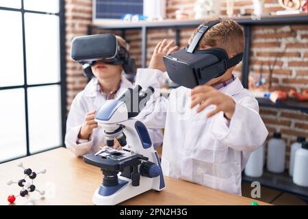 Adorable boys scientist student using virtual reality glasses at laboratory classroom Stock Photo