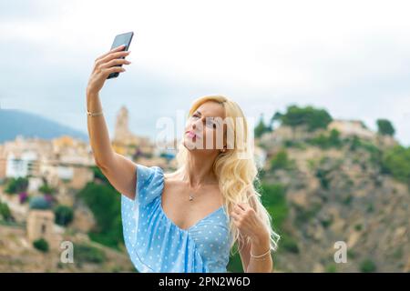 Graceful blonde woman in her 40s taking selfies Stock Photo