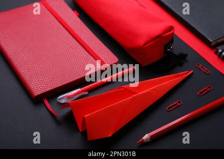 Composition with, notebooks stationery supplies and paper plane on color background Stock Photo