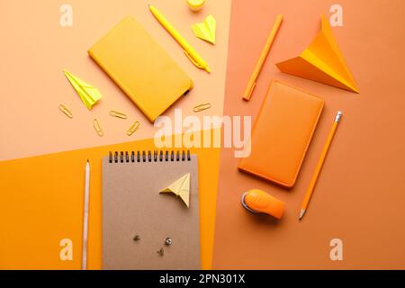 Composition with stationery supplies and paper planes on color background Stock Photo
