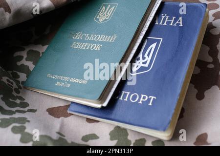 Ukrainian military ID and national passport on military uniform. The concept of mobilization, conscription. War in Ukraine. Stop war Stock Photo