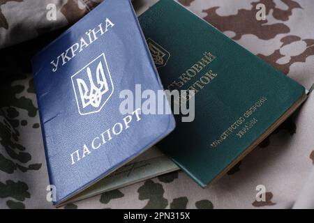 Ukrainian military ID and national passport on military uniform. The concept of mobilization, conscription. War in Ukraine. Stop war Stock Photo