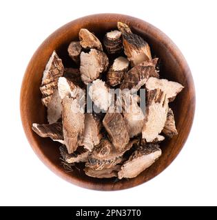 Calamus root in wooden bowl, isolated on white background. Sweet flag, sway or muskrat root. Dry root of Acorus calamus. Top view Stock Photo