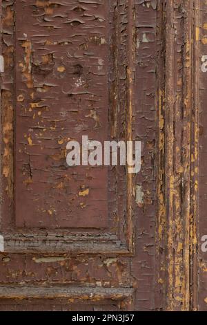 Detail of a brown wooden door with paint peeling off Stock Photo