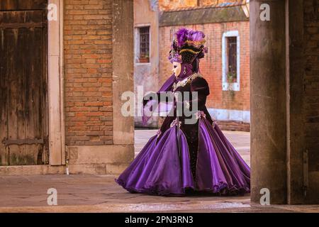 Venice carnival, woman in historic Venetian costume, participant poses in dress, hat and mask, Venezia, Italy Stock Photo
