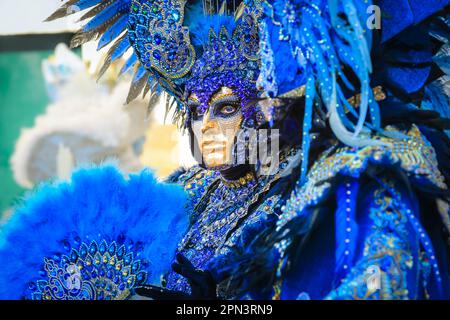 Venice Carnivale, participant in turquoise blue Venetian baroque peacock inspired costume with feathers, mask and hat, Venezia, Italy Stock Photo