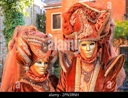 Venice Carnival, female participants in Venetian baroque costumes and masks with elaborate hat, Venezia Italy Stock Photo